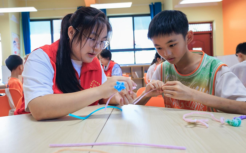 郧西县城关镇王家坪村红军小学爱心托管班的孩子在志愿者带领下做手工。邹景根摄